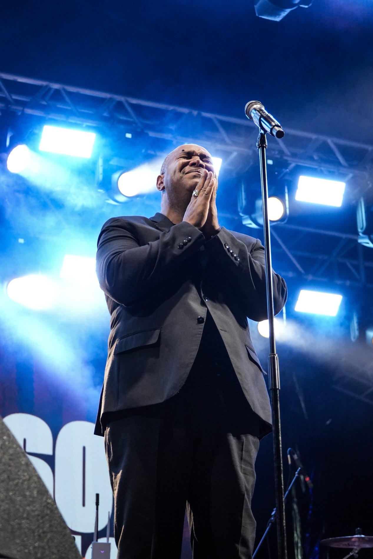 Gerson Rufino com as mãos juntas no palco